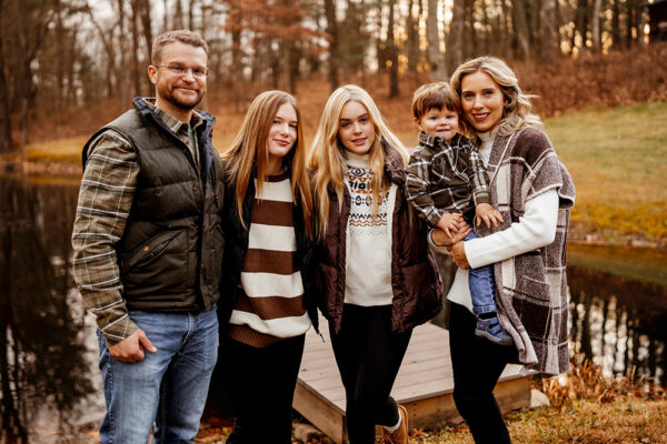 Paul Flint, his two daughters, son and wife standing in front of their pond